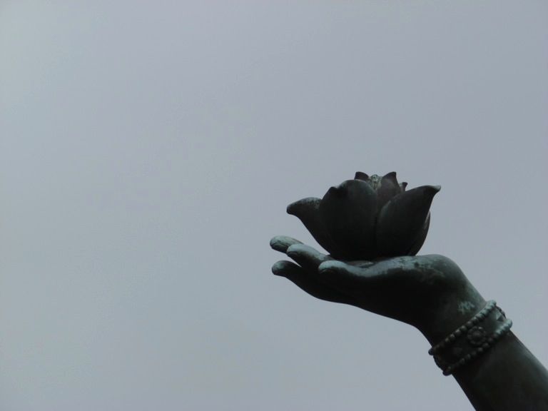 Détail d'une statue, une fleur dans la main