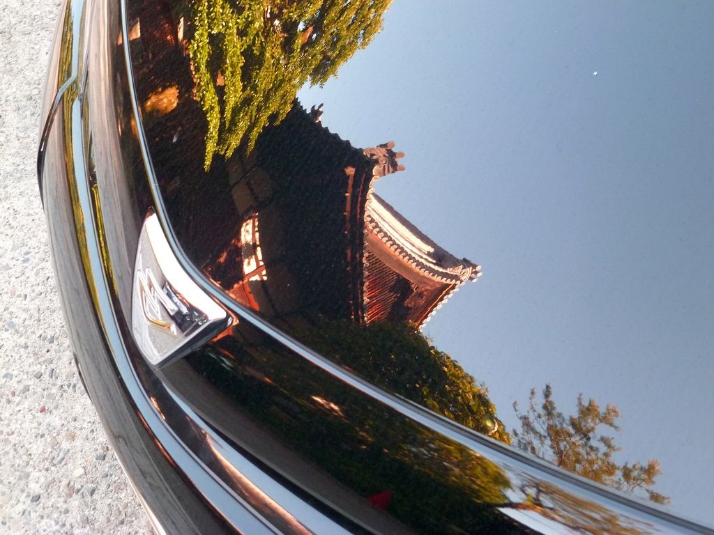 reflet d'un temple sur le capot d'une voiture